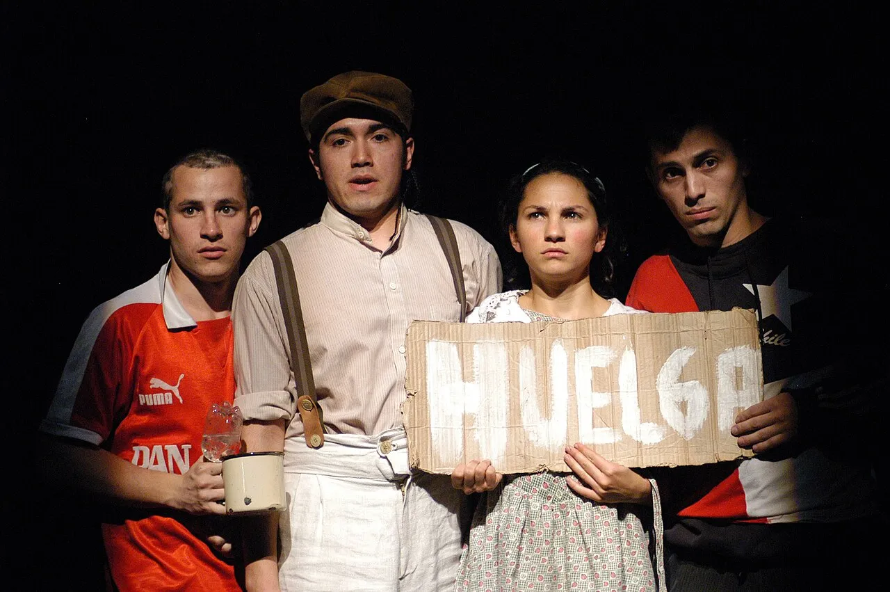 El elenco en plena función, con un cartel de cartón en las manos (imagen de muestra)